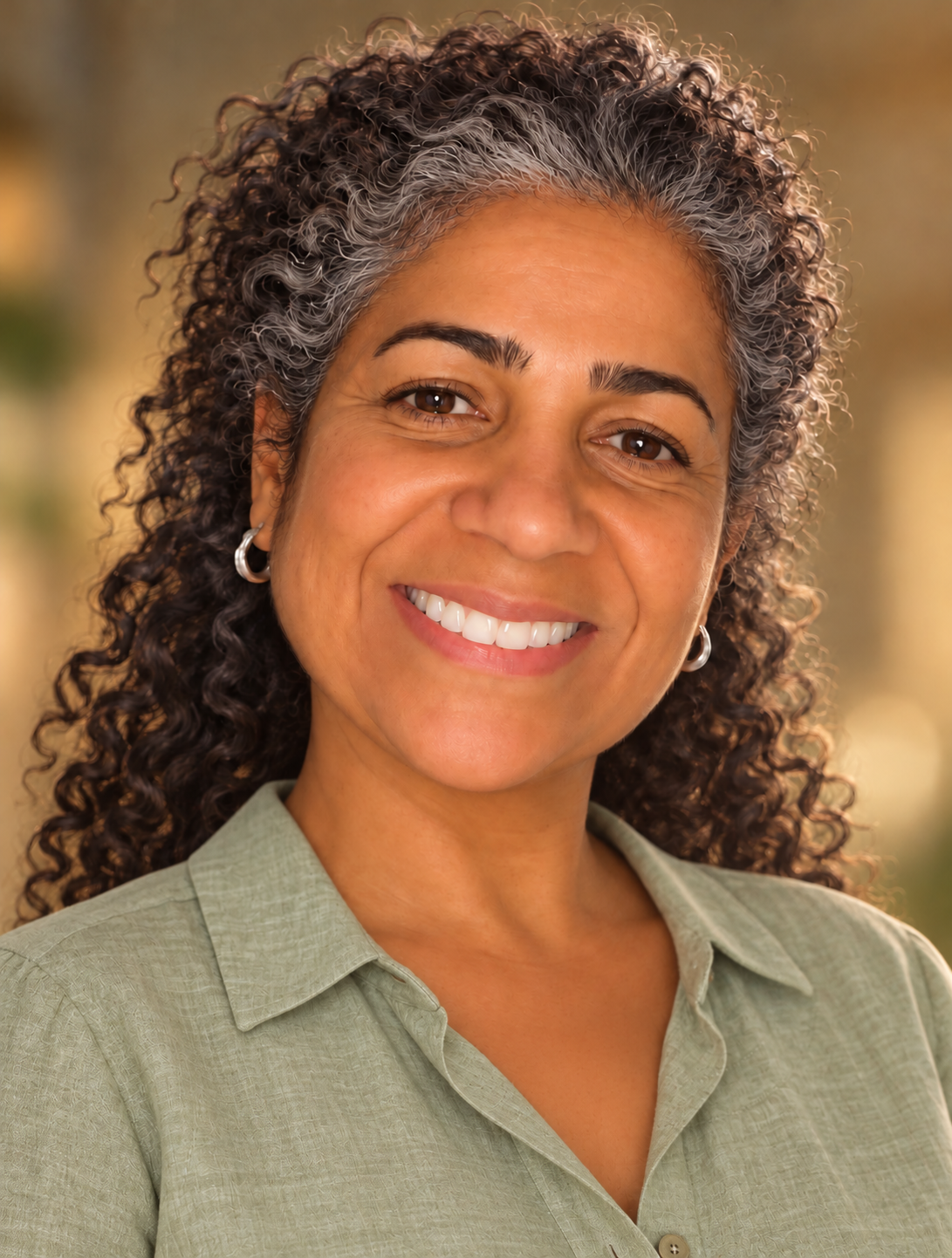 Portrait of Jackie in a sage-green blouse with silver curls framing her face